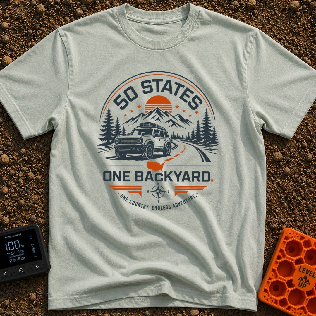 Fifty State Backyard - T-Shirt in Bay - A circular badge design featuring an off-road SUV parked next to a winding road,...