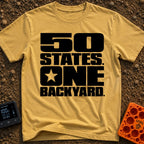 Fifty States One Backyard - T-Shirt in Mustard - Bold black stacked typography that reads "50 STATES. ONE BACKYARD." with...