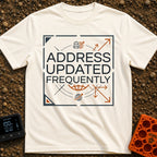 No Fixed Address - T-Shirt in Ivory - The text "ADDRESS UPDATED FREQUENTLY" is centered inside a square border with...