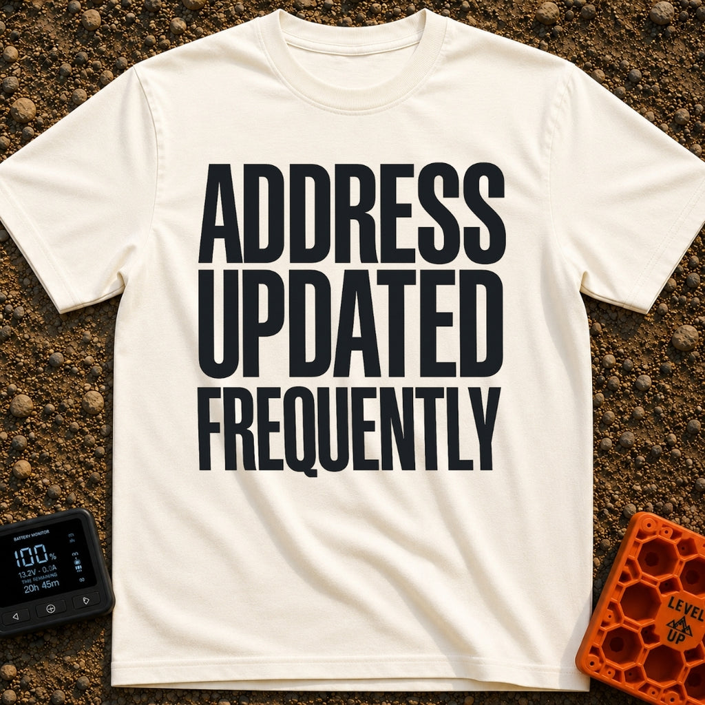 Location Not Found - T-Shirt in Ivory - A text-only design featuring the phrase "ADDRESS UPDATED FREQUENTLY" stacked in...