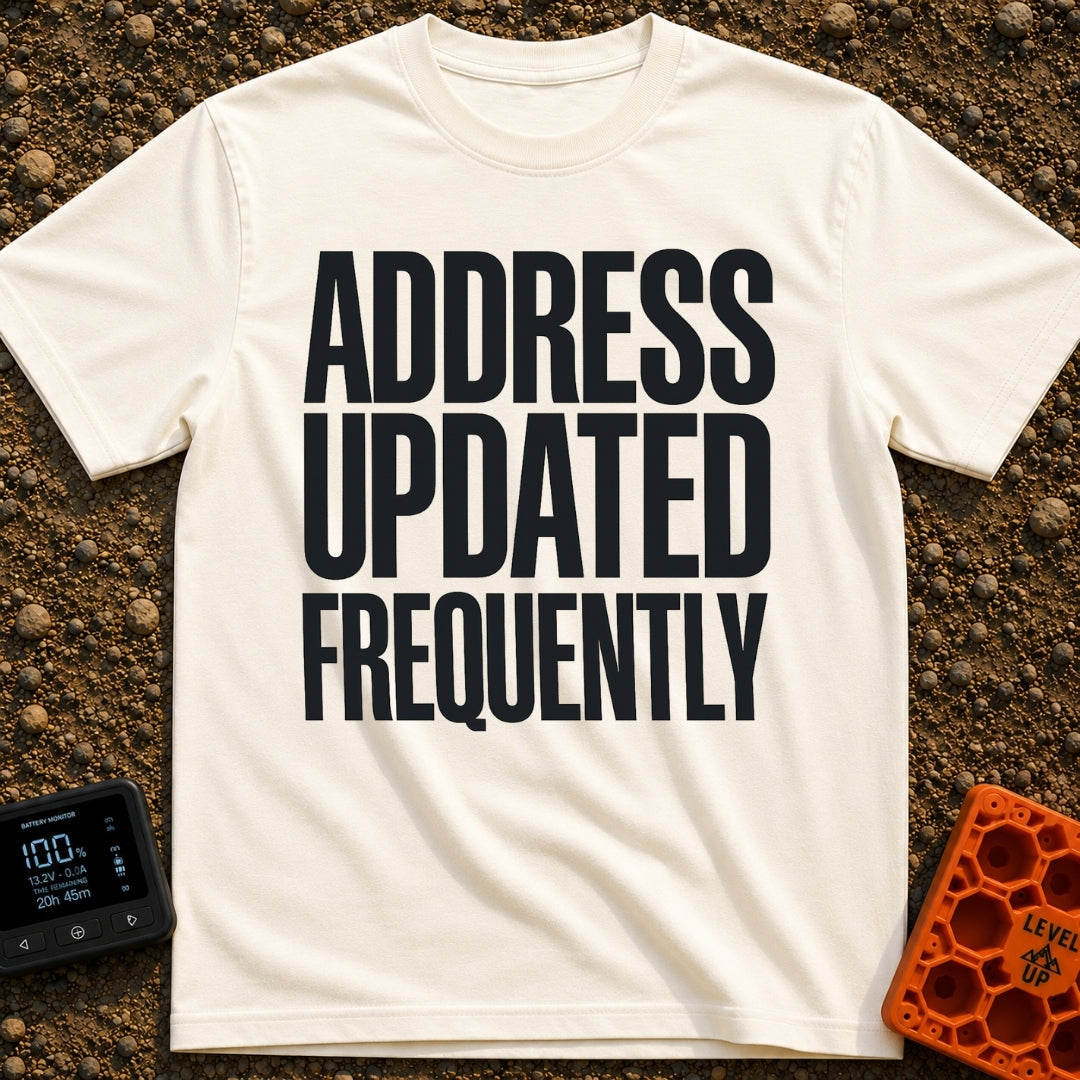 Location Not Found - T-Shirt in Ivory - A text-only design featuring the phrase "ADDRESS UPDATED FREQUENTLY" stacked in...
