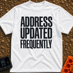 Location Not Found - T-Shirt in White - A text-only design featuring the phrase "ADDRESS UPDATED FREQUENTLY" stacked in...