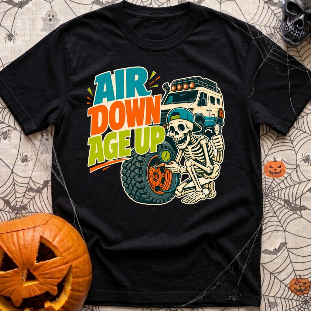 Aired Down Aged Up - T-Shirt in Black - A cartoon skeleton wearing a backwards baseball cap gives a thumbs-up while using...