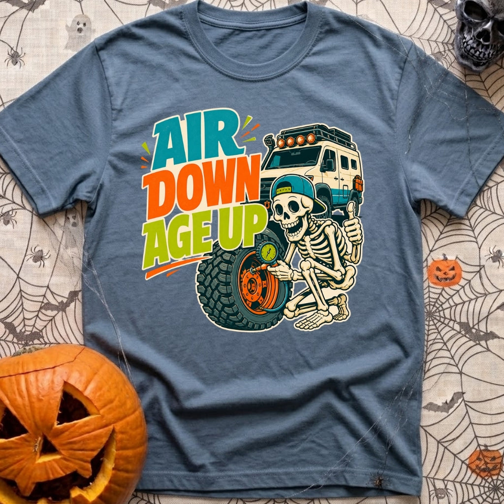 Aired Down Aged Up - T-Shirt in Blue Jean - A cartoon skeleton wearing a backwards baseball cap gives a thumbs-up while...