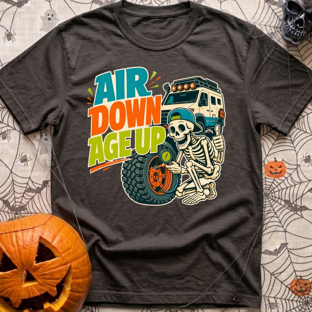 Aired Down Aged Up - T-Shirt in Graphite - A cartoon skeleton wearing a backwards baseball cap gives a thumbs-up while...