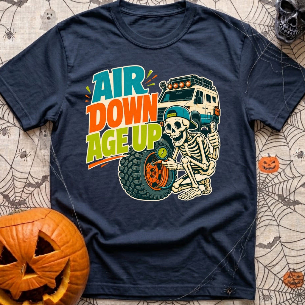 Aired Down Aged Up - T-Shirt in Navy - A cartoon skeleton wearing a backwards baseball cap gives a thumbs-up while using...