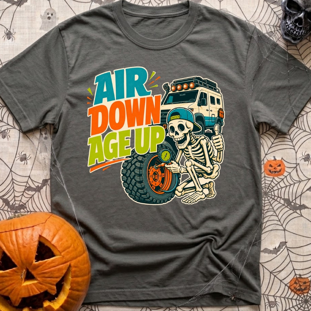 Aired Down Aged Up - T-Shirt in Pepper - A cartoon skeleton wearing a backwards baseball cap gives a thumbs-up while...