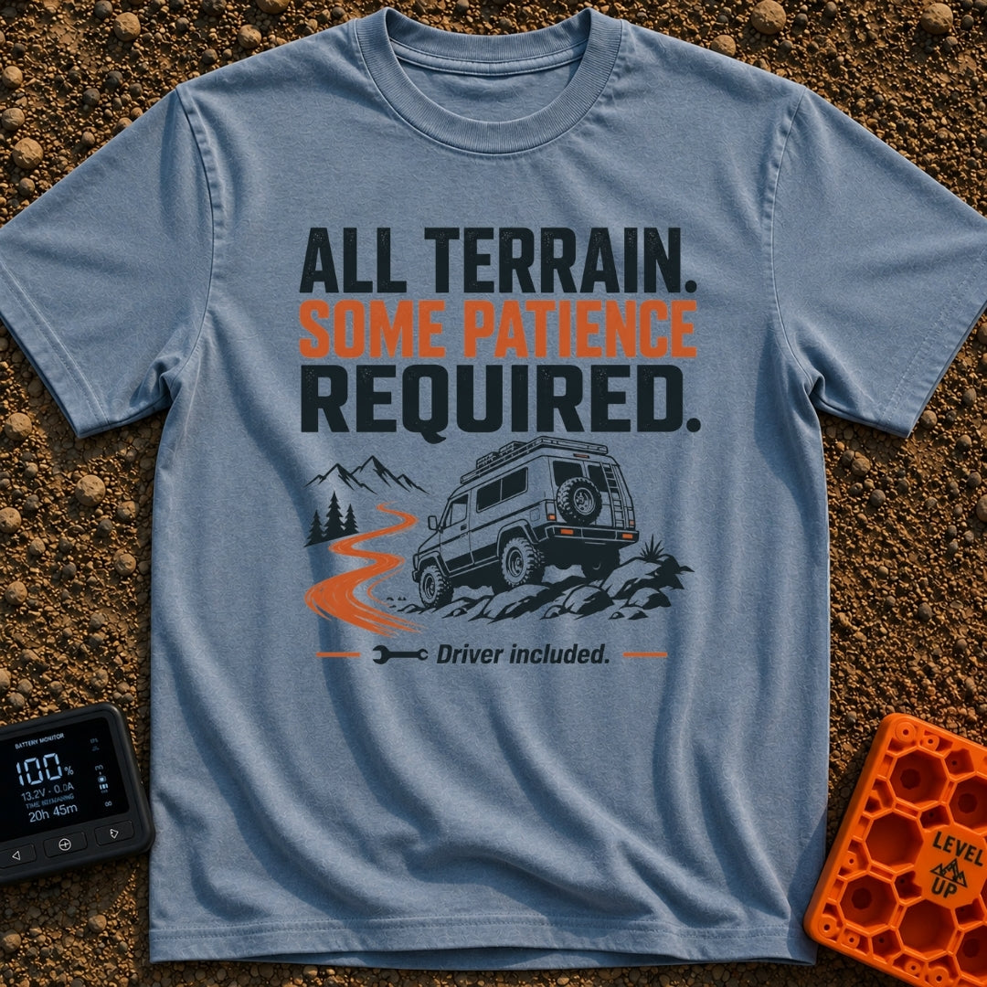 All Terrain Patience Required - T-Shirt in Blue Jean - A rugged camper van is shown driving over a rocky surface beside a...