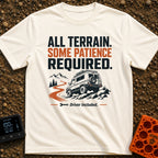 All Terrain Patience Required - T-Shirt in Ivory - A rugged camper van is shown driving over a rocky surface beside a...
