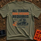 All Terrain Patience Required - T-Shirt in Moss - A rugged camper van is shown driving over a rocky surface beside a...