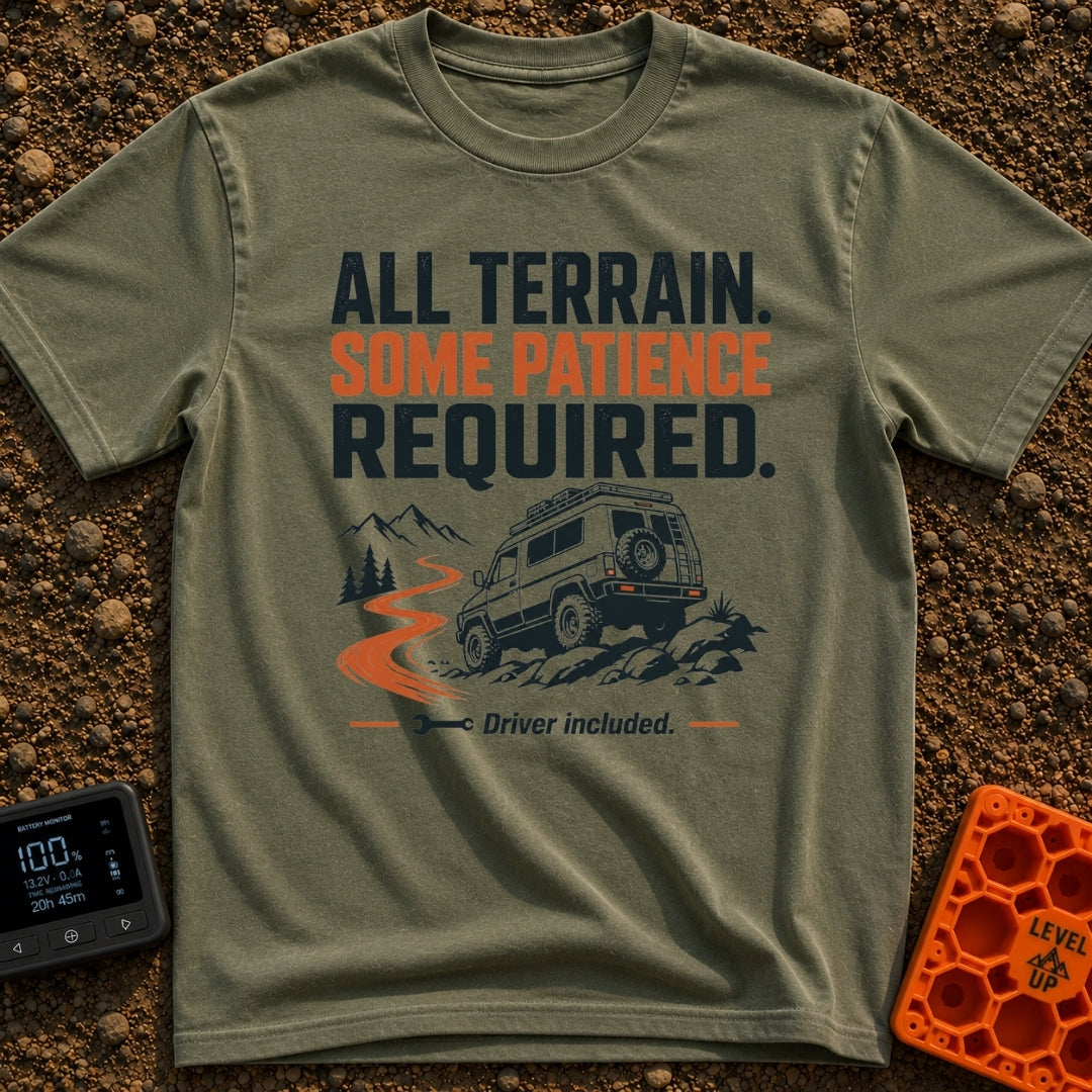 All Terrain Patience Required - T-Shirt in Moss - A rugged camper van is shown driving over a rocky surface beside a...