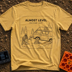Looks Level From Here - T-Shirt in Mustard - A black-and-white line drawing of a bearded man kneeling and thoughtfully...