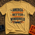 Better Through A Windshield - T-Shirt in Mustard - Text reading "AMERICA LOOKS BETTER THROUGH A WINDSHIELD" surrounded by...