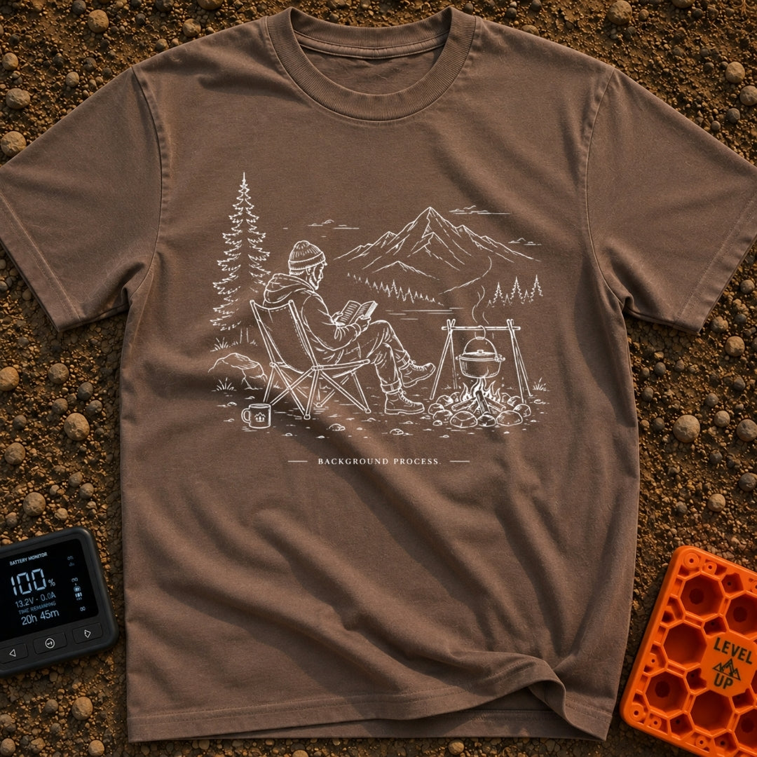 Running In The Background - T-Shirt in Espresso - A line-art illustration of a man wearing a beanie sitting in a camp...