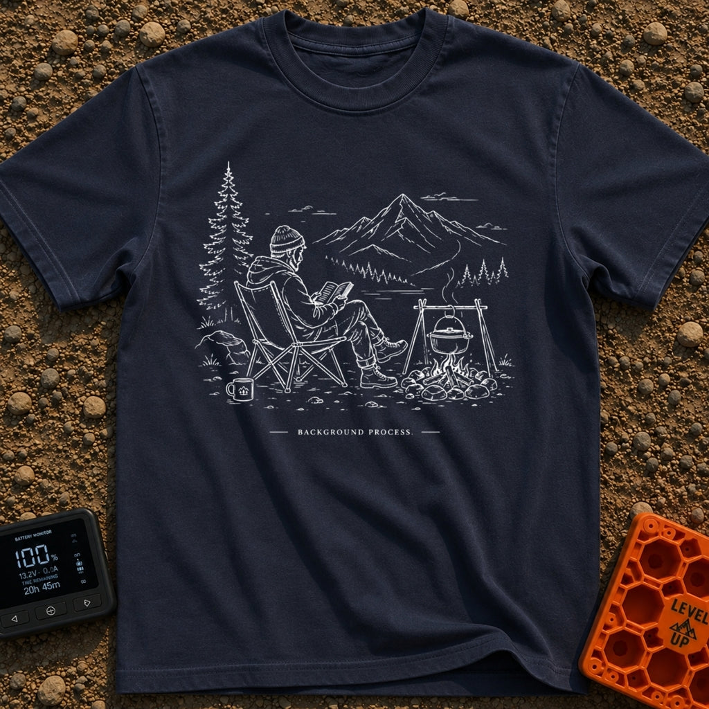 Running In The Background - T-Shirt in Navy - A line-art illustration of a man wearing a beanie sitting in a camp chair...