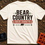 Character In Bearland - T-Shirt in Ivory - A vintage-style typographic design featuring the text "BEAR COUNTRY BUILDS...
