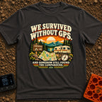 Lost In The Fold - T-Shirt in Graphite - A retro-style illustration featuring an unfolded paper map and a compass in the...