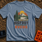 Bigfoot Believes In Us - T-Shirt in Blue Jean - A graphic showing a silhouette of Bigfoot peeking from behind a large...