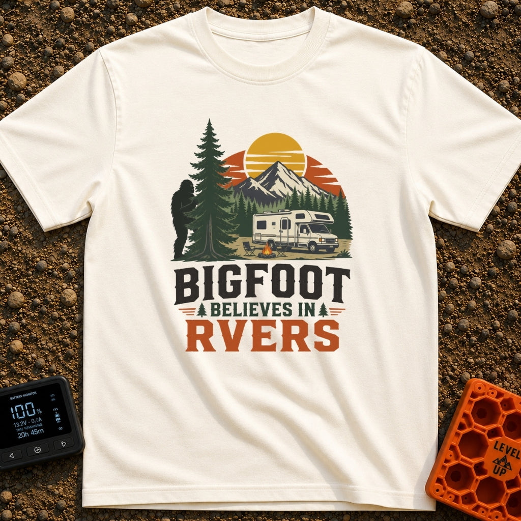 Bigfoot Believes In Us - T-Shirt in Ivory - A graphic showing a silhouette of Bigfoot peeking from behind a large pine...