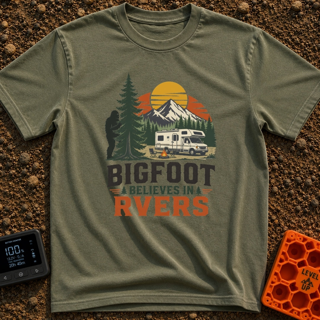 Bigfoot Believes In Us - T-Shirt in Moss - A graphic showing a silhouette of Bigfoot peeking from behind a large pine...