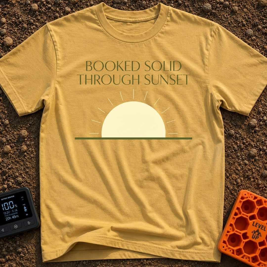 Booked Till Sunset - T-Shirt in Mustard - The image features the text "BOOKED SOLID THROUGH SUNSET" in a dark olive...