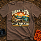 Born In A Barn - T-Shirt in Espresso - A retro-style illustration of a vintage Class A motorhome driving along a winding...
