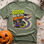 Brooms Turn Better - T-Shirt in Moss - A cartoon illustration showing a witch flying effortlessly in a tight circle...