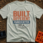 Built Different Parked - T-Shirt in Bay - A typographic design reading 'BUILT DIFFERENT' and 'PARKED BETTER' in large...