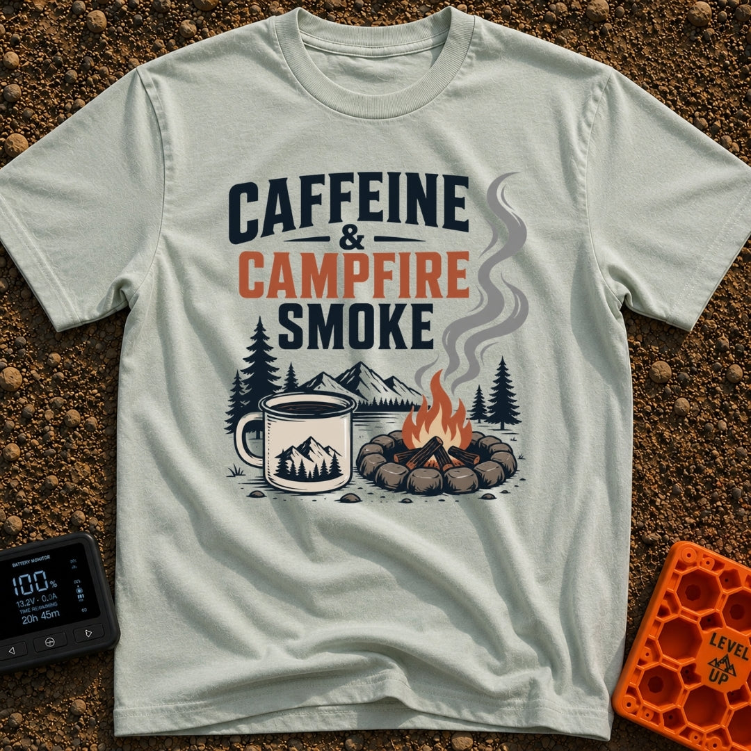 Caffeine And Campfires - T-Shirt in Bay - A large camp mug filled with coffee next to a stone-ringed campfire with rising...