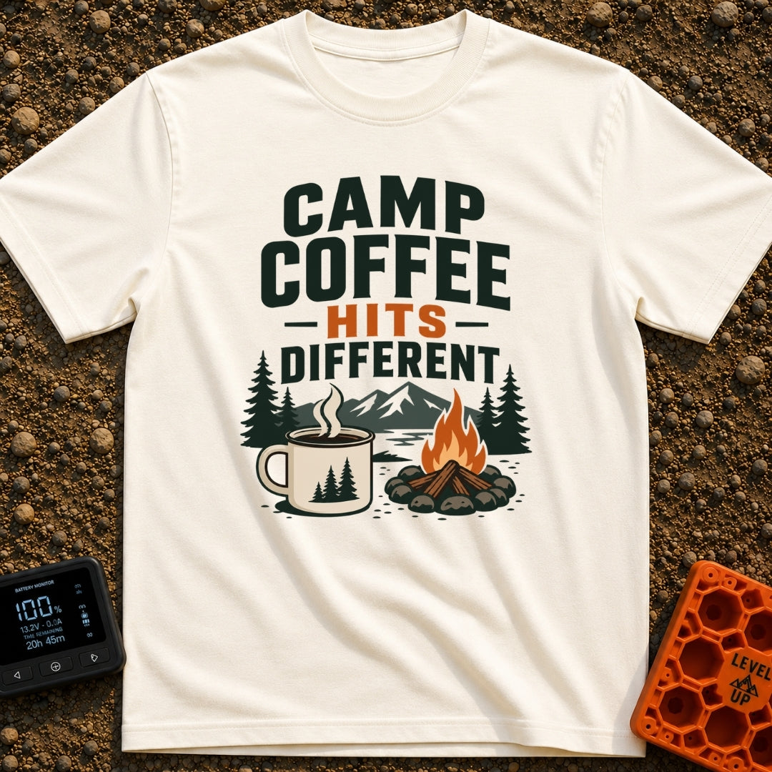 Brew Hits Different - T-Shirt in Ivory - A graphic showing a steaming enamel camp mug next to a stone-ringed campfire,...