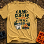 Brew Hits Different - T-Shirt in Mustard - A graphic showing a steaming enamel camp mug next to a stone-ringed campfire,...