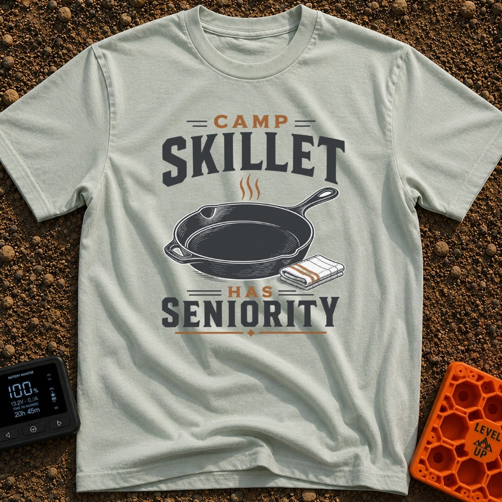 Skillet Has Seniority - T-Shirt in Bay - A graphic illustration of a steaming cast-iron skillet next to a folded striped...