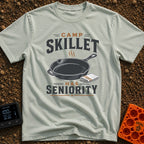 Skillet Has Seniority - T-Shirt in Bay - A graphic illustration of a steaming cast-iron skillet next to a folded striped...
