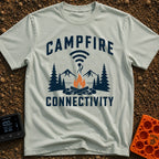 The Original Hot Spot - T-Shirt in Bay - A graphic illustration featuring a campfire in a rock ring with pine trees and...