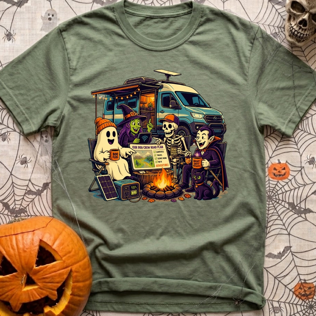 Unexplainable Campfire Attendance - T-Shirt in Moss - A cartoon illustration of a ghost, witch, skeleton, and vampire...