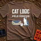 Cat Logic Certified - T-Shirt in Espresso - A black and white cat sitting upright next to an empty round pet bed, with a...