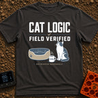 Cat Logic Certified - T-Shirt in Graphite - A black and white cat sitting upright next to an empty round pet bed, with a...