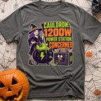 Watts In The Cauldron - T-Shirt in Pepper - A cartoon witch with purple hair stirs a bubbling green cauldron that is...