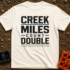 Creek Miles Count Double - T-Shirt in Ivory - A text-based design featuring the words 'CREEK MILES' and 'DOUBLE' in large...