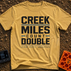 Creek Miles Count Double - T-Shirt in Mustard - A text-based design featuring the words 'CREEK MILES' and 'DOUBLE' in...
