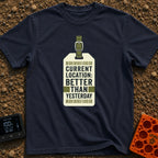 Better Than Yesterday - T-Shirt in Navy - A graphic of a vintage-style luggage tag with an olive green buckled strap,...