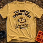 That Check Engine Glow - T-Shirt in Mustard - A graphic design featuring the text "THE CHECK ENGINE LIGHT" in distressed...