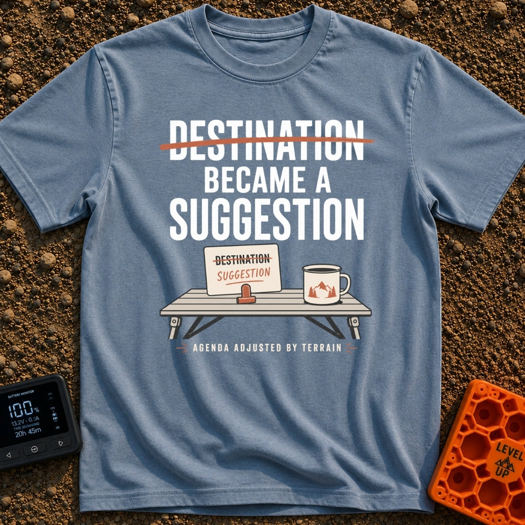 Destinations Are Suggestions - T-Shirt in Blue Jean - A folding camp table holds a coffee mug with a mountain graphic and...