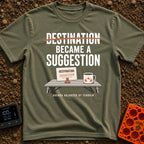 Destinations Are Suggestions - T-Shirt in Moss - A folding camp table holds a coffee mug with a mountain graphic and a...