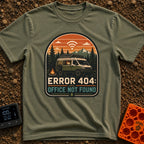 404 Office Not Found - T-Shirt in Moss - A green camper van with a roof-mounted solar panel is parked in a forest next to...