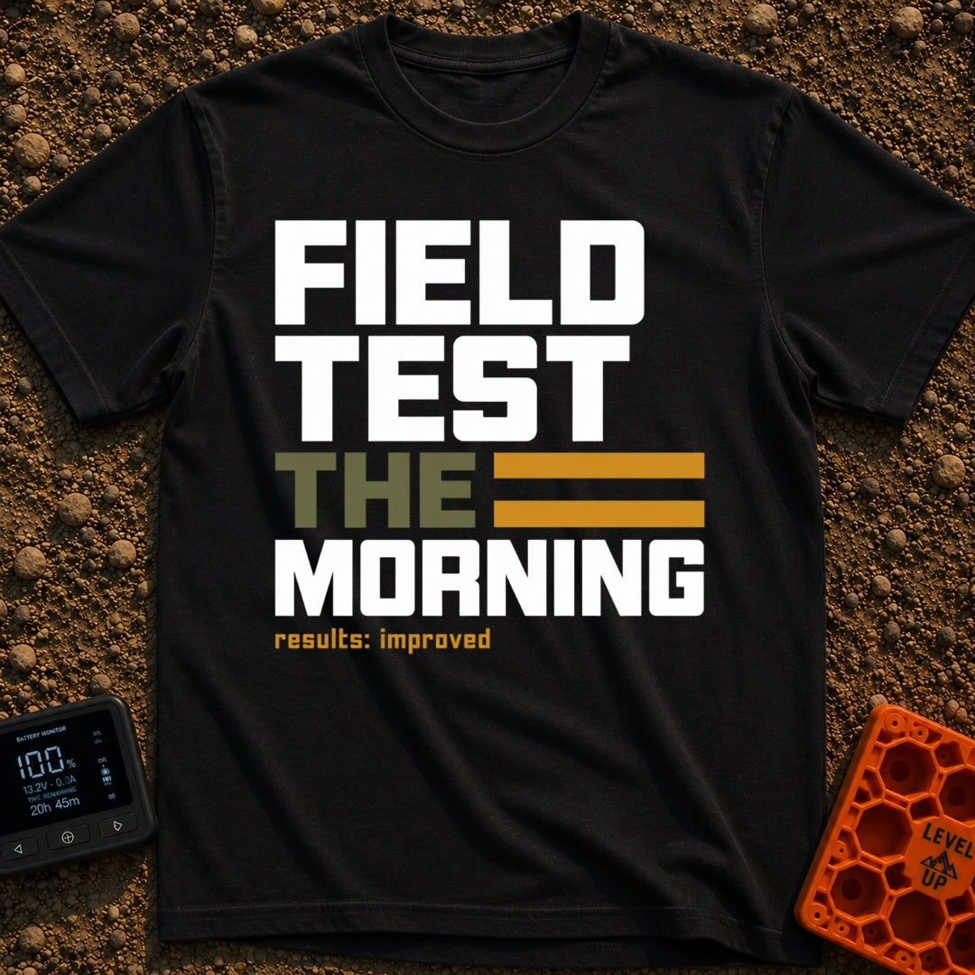 Morning Field Trials - T-Shirt in Black - A typographic design featuring the stacked words "FIELD TEST THE MORNING", with...