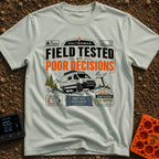 Tested By Poor Decisions - T-Shirt in Bay - The design features a camper van parked on rocky terrain with mountains and...