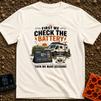 First Check The Battery - T-Shirt in Ivory - A white camper van with a roof-mounted solar panel parked near mountains and...
