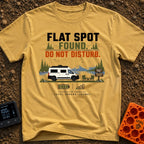 Flat Spot Found - T-Shirt in Mustard - A white camper van parked beside a lake with mountains in the background, next to...