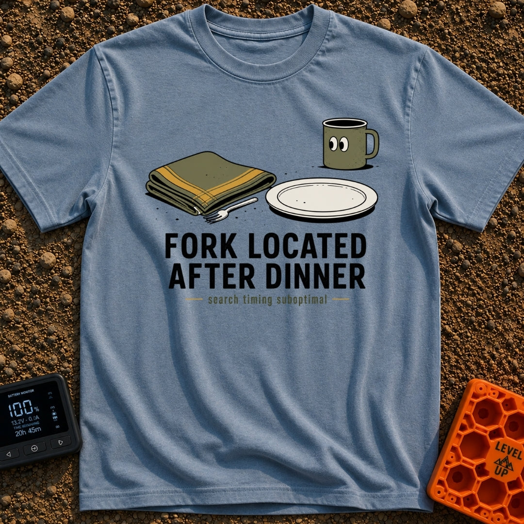 Fork Found Too Late - T-Shirt in Blue Jean - A cartoon illustration showing a fork partially hidden under a folded green...
